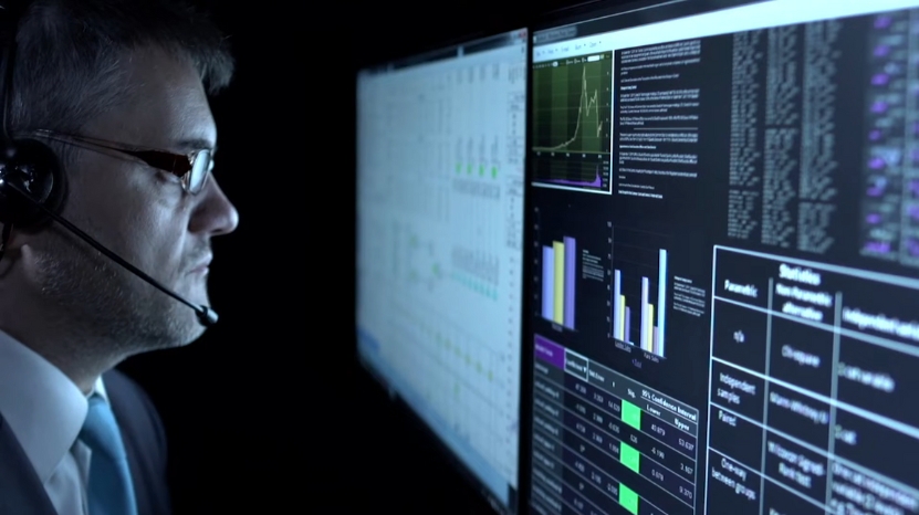 Analyst at a computer monitors data dashboards for MSBA level work
