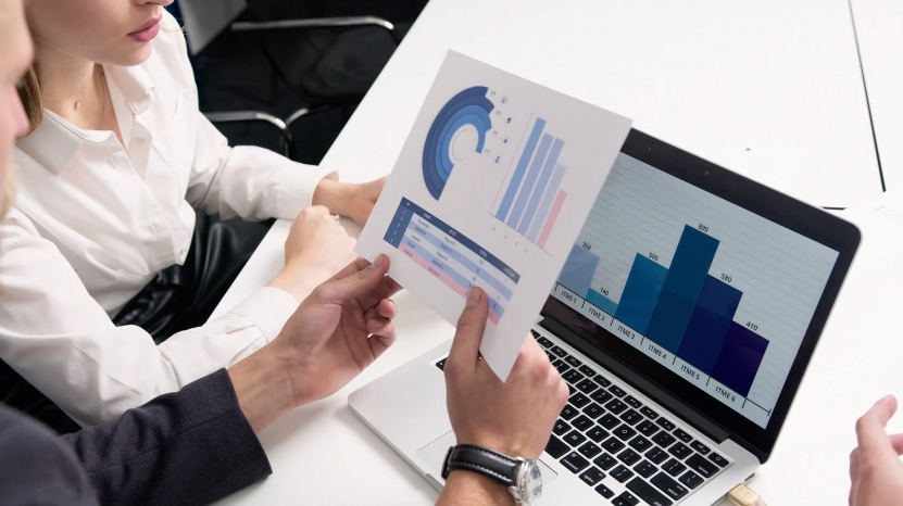 Colleagues review marketing charts and growth data on a laptop