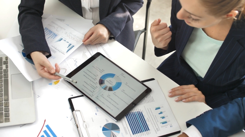 Team reviews strategy charts on a tablet during a consulting meeting