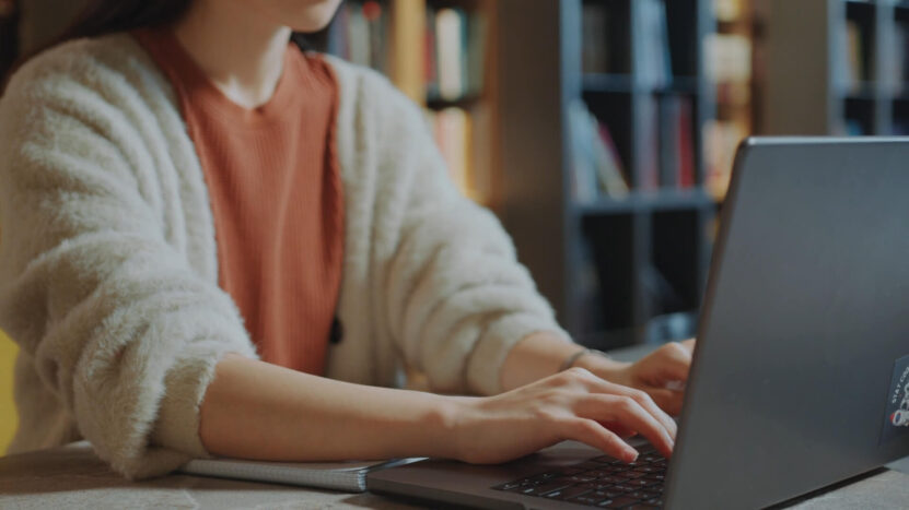 A girl is typing on a laptop