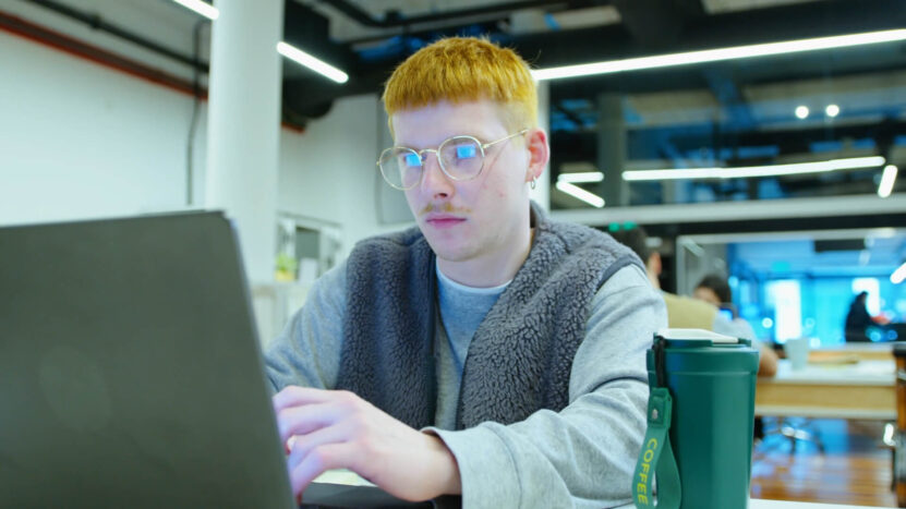 A guy is studying on a laptop in a café