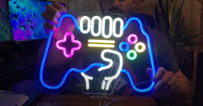 A guy is holding a neon sign