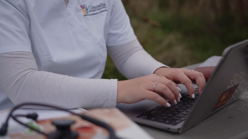 A Healthcare Worker Typing on A Laptop to Support Patient Care with Data