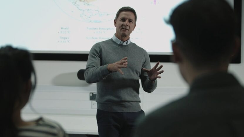 A man delivers a lecture in a modern classroom